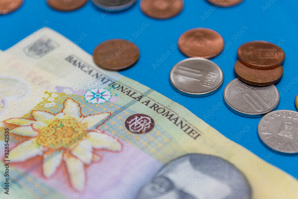 Romanian banknotes and coins on a blue and red background. Coloseup of RON, Romanian Currency. Romanian RON, Lei Banknotes issued by BNR, National Bank of Romania. Romania Finance and economy concept