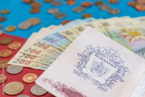 Obraz na płótnie Romanian concept. The Romanian passport and Romanian banknotes/coins on a blue and red background. Coloseup of Romanian Passport and Romanian currency. Romania Finance and economy concept w salonie