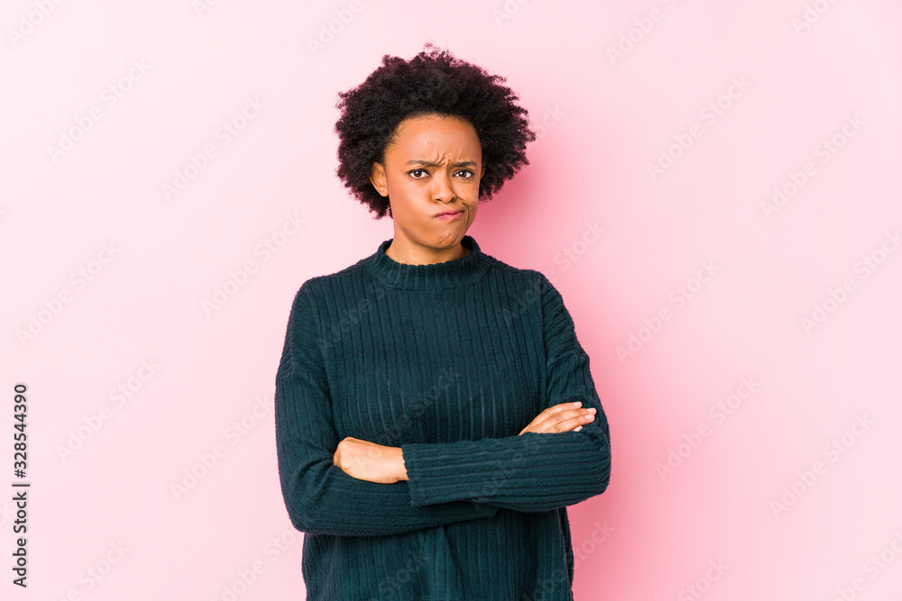 Middle aged african american woman against a pink background isolated unhappy looking in camera with sarcastic expression. Middle aged african american woman against a pink background isolated unhappy looking in camera with sarcastic expression.