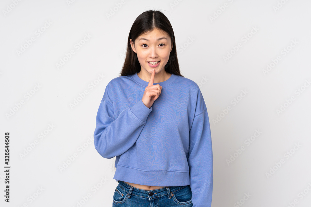 Young asian woman isolated on background showing a sign of silence gesture putting finger in mouth Young asian woman isolated on background showing a sign of silence gesture putting finger in mouth
