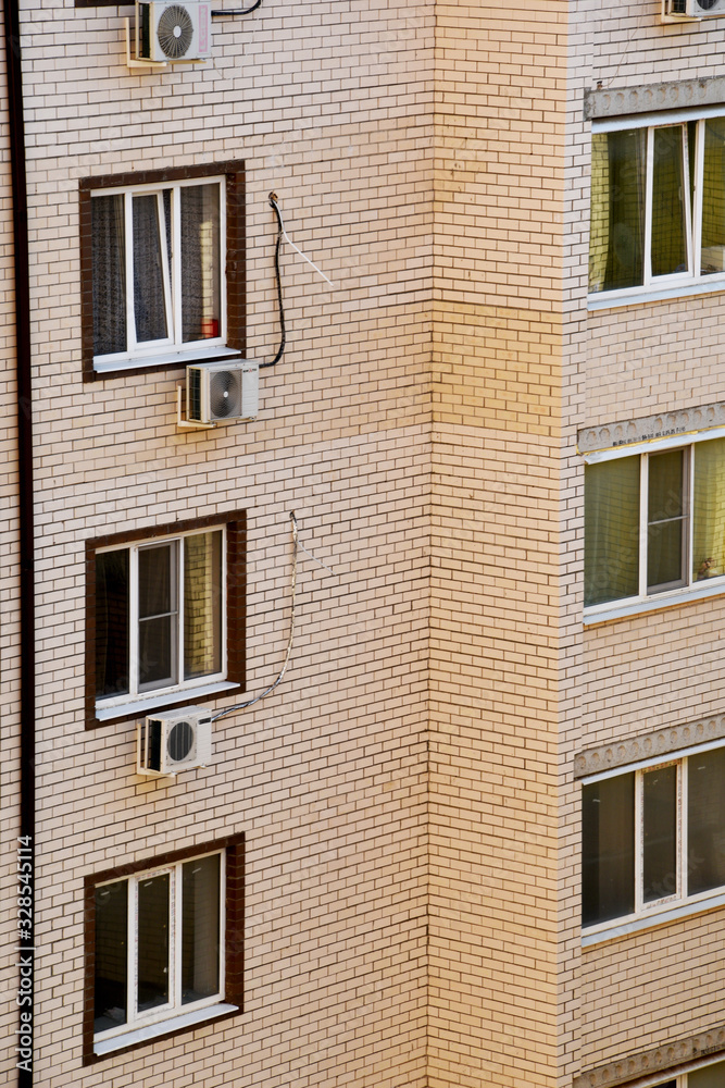 Part of the building, light brick facing, balconies and air conditioning. Large windows at the multi-storey new building.