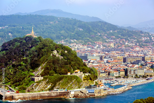 View from mount Igueldo to mount Urgull of the Bay of Biscay on the background of the Pyrenees mountains, San Sebastian, Donostia, Spain photo