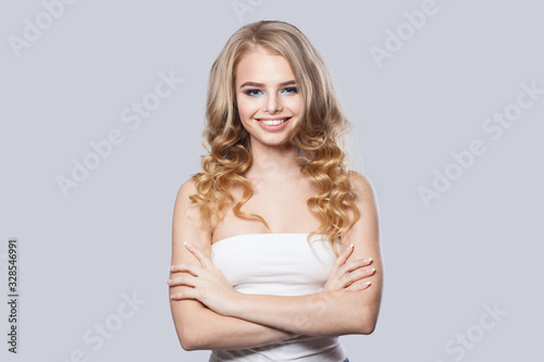 Portrait of happy woman with long healthy curly hair posing on white background