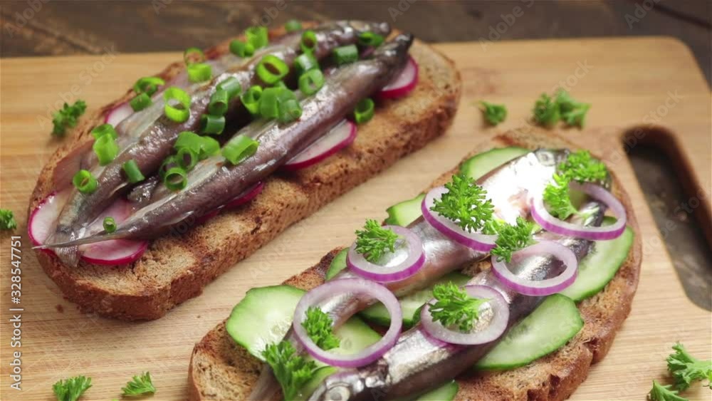 open sandwiches with salted capelin cucumber rye bread parsley red onion panning shot