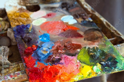 artist wooden palette, mess of fresh bright colorful oil paints mixed in disorder, outdoor painting plein air, creative vibrant inspiration postcard