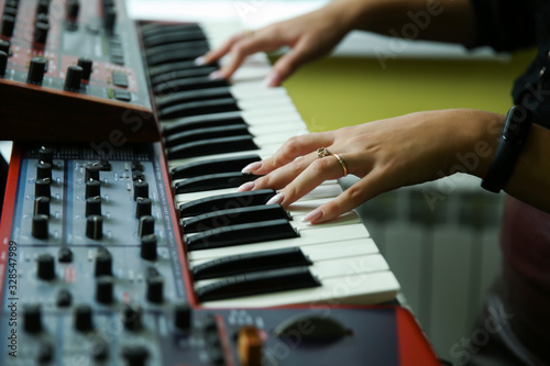 woman's hands are playing the synthesizer close up