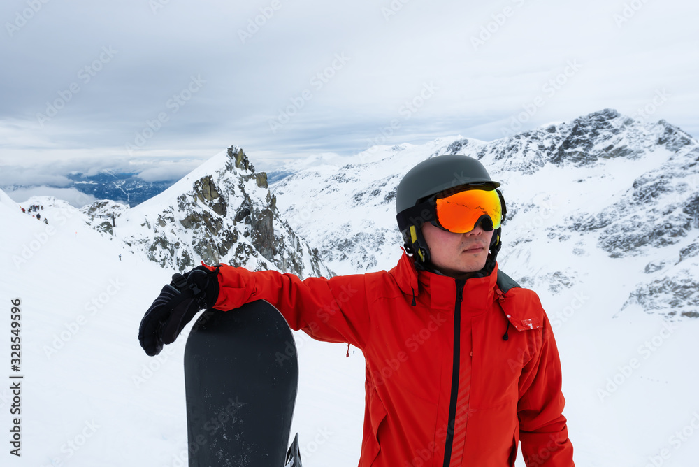 Whistler, British Columbia, Canada. Adventurous Man with a snowboard in the Alpines on top of Blackcomb Mountain. Portrait