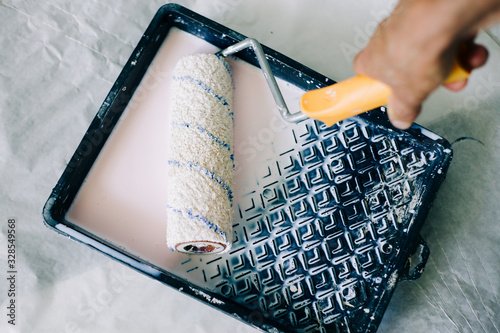 the roller is wetted in a liquid primer in a plastic black container, before painting the walls with paint