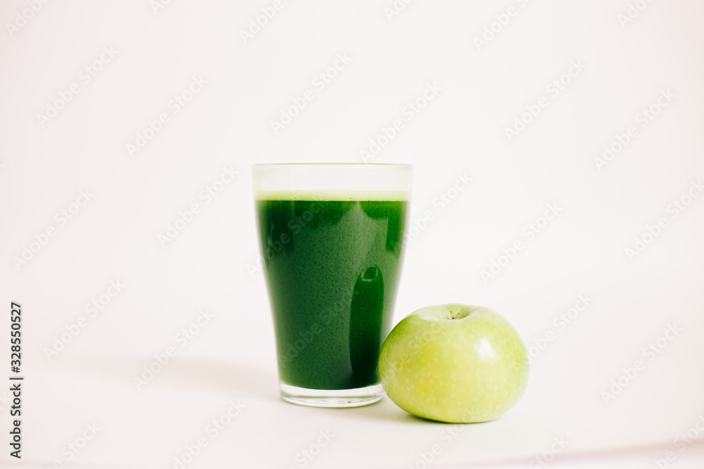 green freshly squeezed juice of green Apple and young spinach leaves on a white background green freshly squeezed juice of green Apple and young spinach leaves on a white background