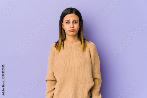 Young woman isolated on purple background sad, serious face, feeling miserable and displeased.