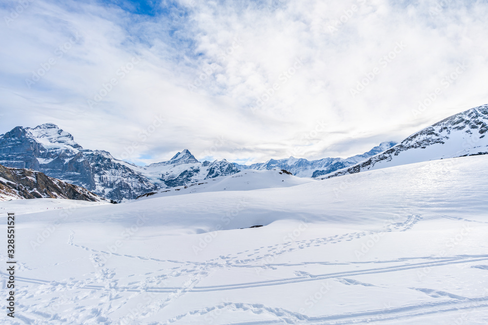 Winter landscape with snow covered peaks seen from the First mountain in Swiss Alps in Grindelwald ski resort, Switzerland Winter landscape with snow covered peaks seen from the First mountain in Swiss Alps in Grindelwald ski resort, Switzerland