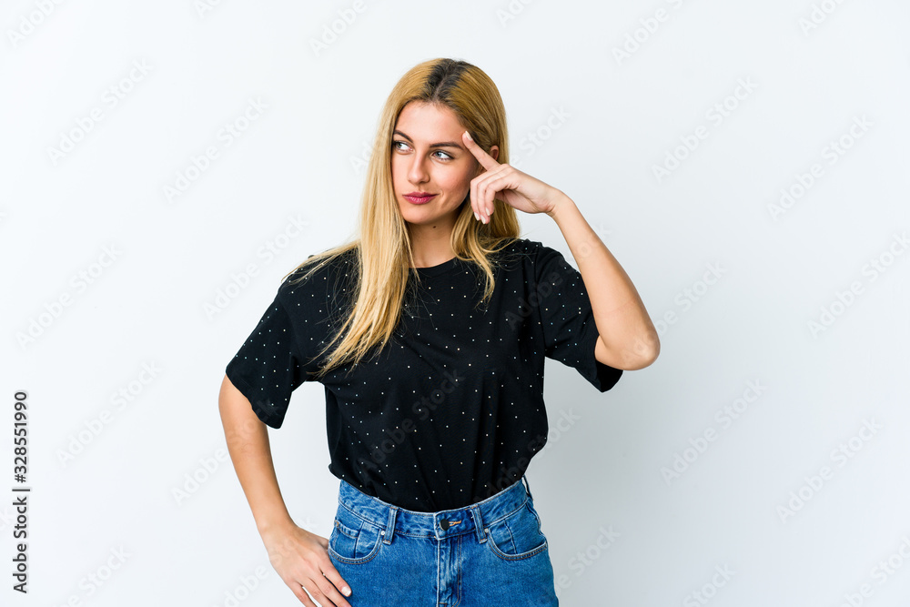 Young blonde woman isolated on white background pointing temple with finger, thinking, focused on a task. Young blonde woman isolated on white background pointing temple with finger, thinking, focused on a task.