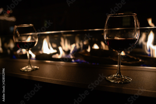 pair of glasses of wine by fire