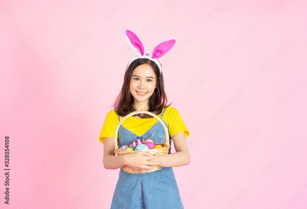 Asian woman wear bunny ear hold easter eggs basket Asian woman wear bunny ear hold easter eggs basket