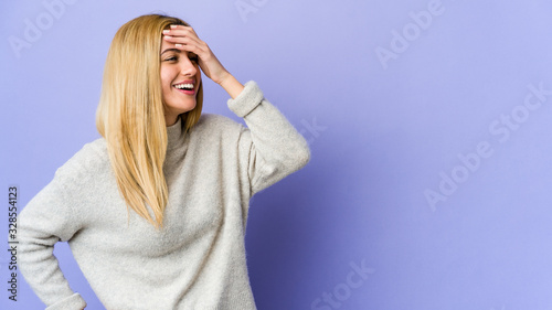 Young blonde woman isolated on purple background joyful laughing a lot. Happiness concept.