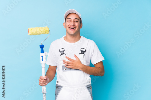 Fototapeta Naklejka Na Ścianę i Meble -  Young professional painter latin man isolated laughs out loudly keeping hand on chest.
