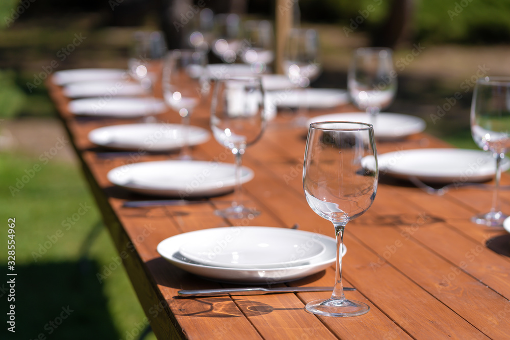 Fototapeta premium Served wooden table without a tablecloth. Cafe in the open air park