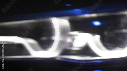 Adaptive LED optics luxury black car, close shot, color light and smoke