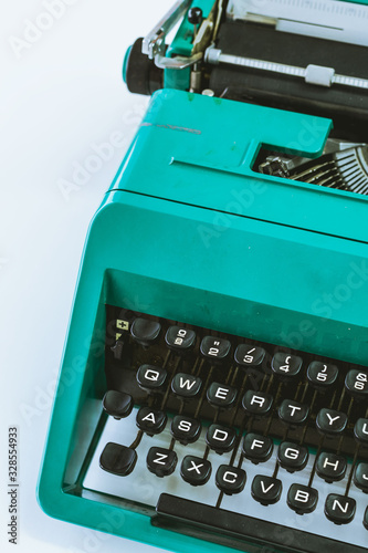 Tableau sur toile Old typewriter of green color on a white background