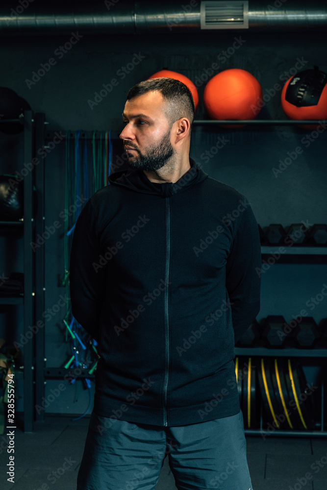 Portrait of a young muscular trainer in fitness center or gym. Fitness, sport, exercising and diet concept. Portrait of a young muscular trainer in fitness center or gym. Fitness, sport, exercising and diet concept.