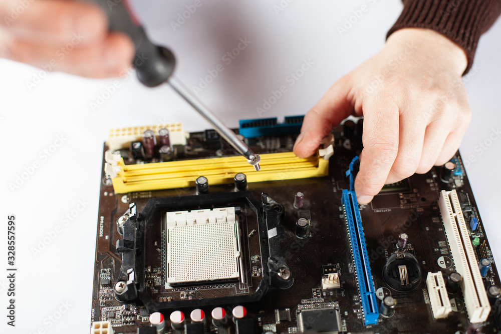 Computer motherboard repair. Fixing a board on a white background. Computer motherboard repair. Fixing a board on a white background.