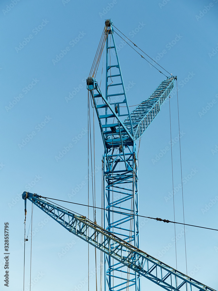 Two blue cranes over clean blue sky background Two blue cranes over clean blue sky background