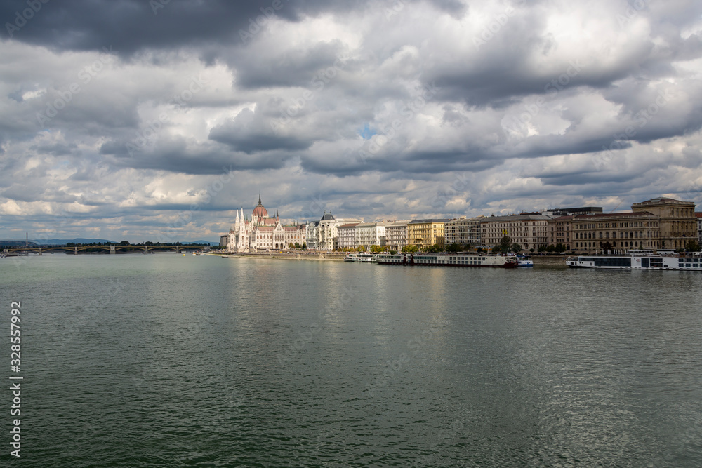 The hungarian Parliament in Budapest. Danube river. Cloudy sky.