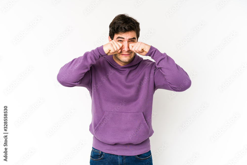 Fototapeta premium Young man isolated on white background whining and crying disconsolately.