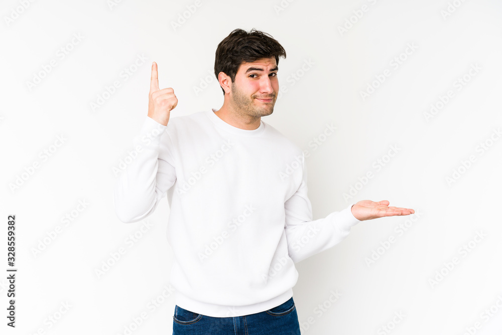 Young man isolated on white background holding and showing a product on hand. Young man isolated on white background holding and showing a product on hand.