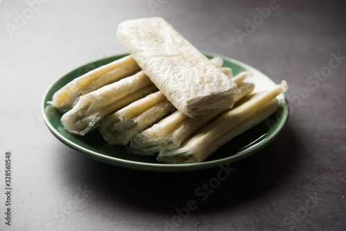 Pootharekulu  is a popular recipe originated from Andhra Pradesh, India.It is a paper-thin sweet or dessert made from rice start/gram flour, jaggery/sugar and clarified butter. Served in a plate. photo