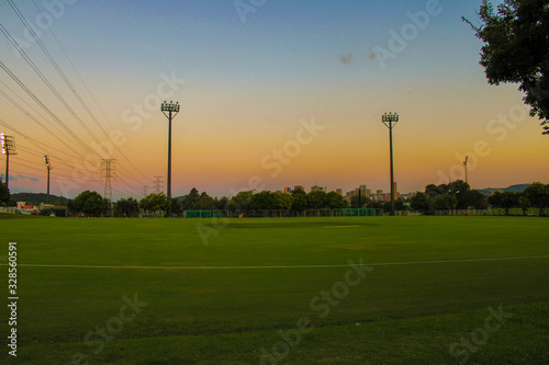 field at sunset, summer, green, grass, city, lights, trees, flats, sky, landscape, agriculture, soccer, football, cricket, sports, plants, electricity, fields, nature, creation, orange, creavity