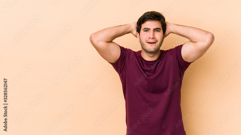Young man isolated on beige background screaming, very excited, passionate, satisfied with something. Young man isolated on beige background screaming, very excited, passionate, satisfied with something.