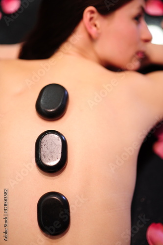 Beautiful woman having lava stones massage in spa