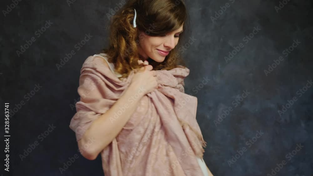 Feminine pregnant young woman with curly hair smiling and dancing standing over dark wall. Happy pregnancy. Feminine pregnant young woman with curly hair smiling and dancing standing over dark wall. Happy pregnancy.