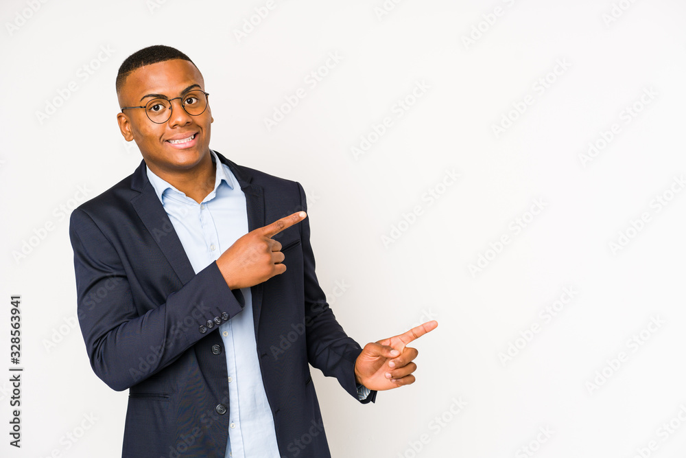 Young business latin man isolated on white background shocked pointing with index fingers to a copy space. Young business latin man isolated on white background shocked pointing with index fingers to a copy space.