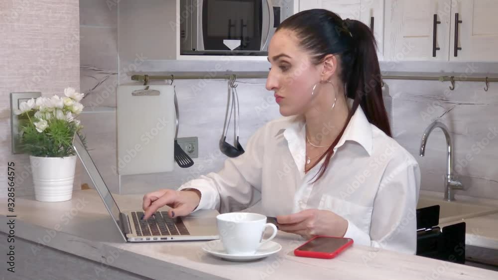 Woman pays for purchase online by credit card using a laptop Woman pays for purchase online by credit card using a laptop
