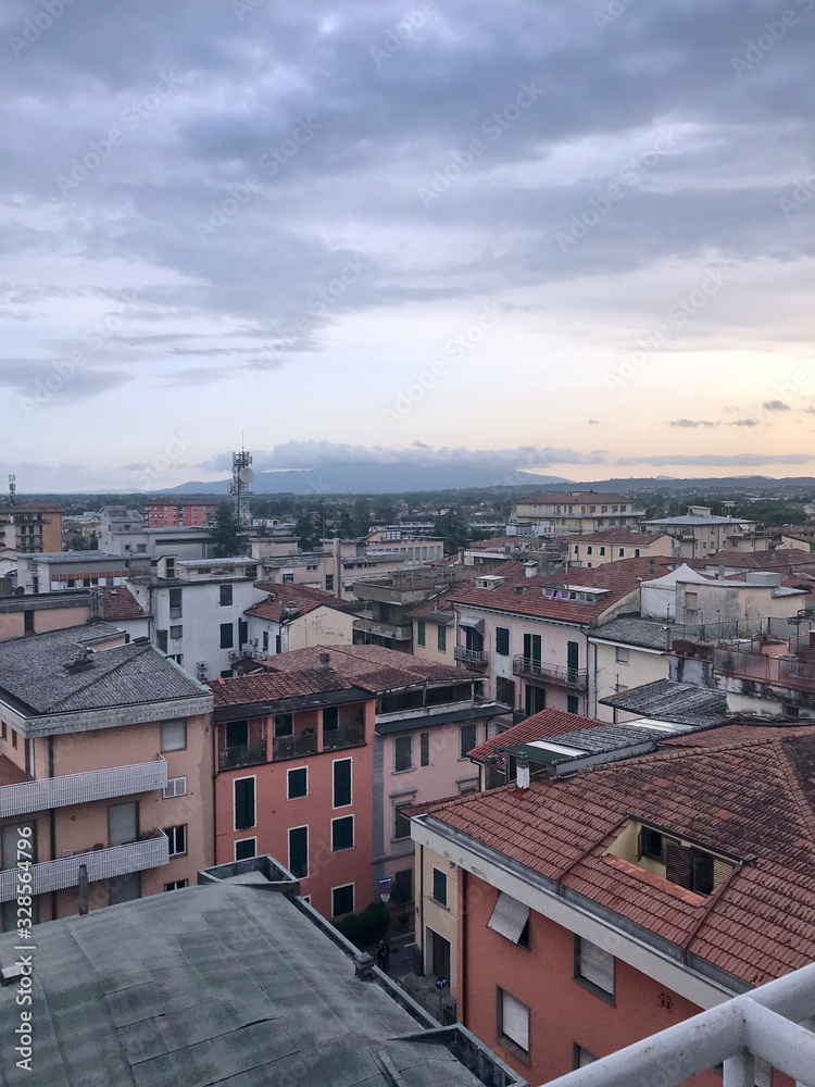 Top view of an ancient italian town on a background of mountain ranges on the horizon at sunset.