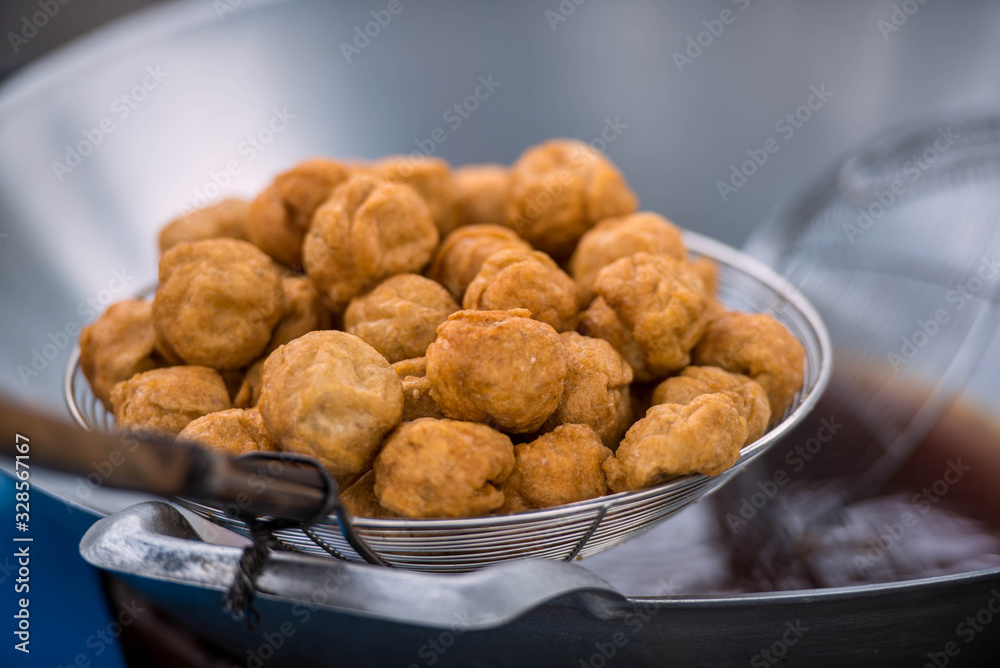 Hand of chef holding frying pan cooking fry the fish balls on a pan in kitchen stove, fried food concept. Hand of chef holding frying pan cooking fry the fish balls on a pan in kitchen stove, fried food concept.