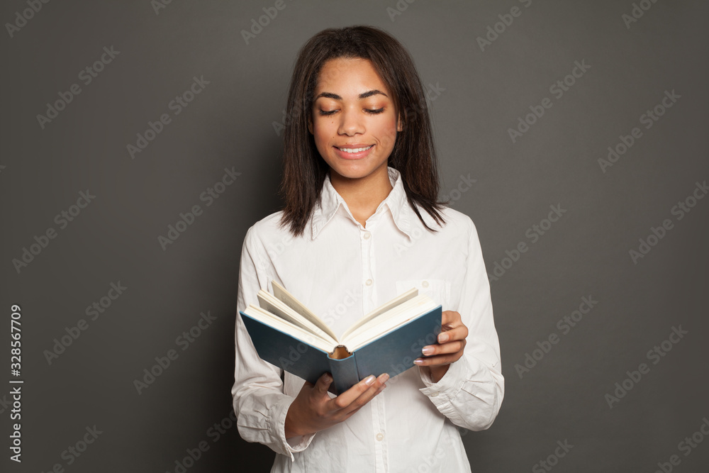 Pretty young black woman student reading a book Pretty young black woman student reading a book