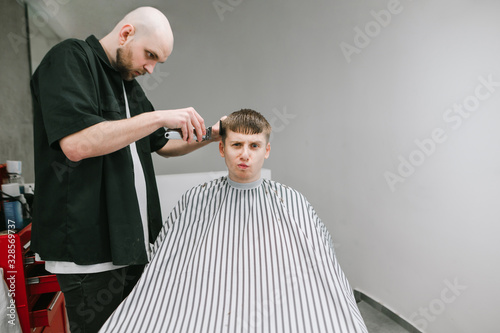 Billede på lærred Barber Hair Clipper Hair Clipper Funny Client With Serious Face And Gray Background