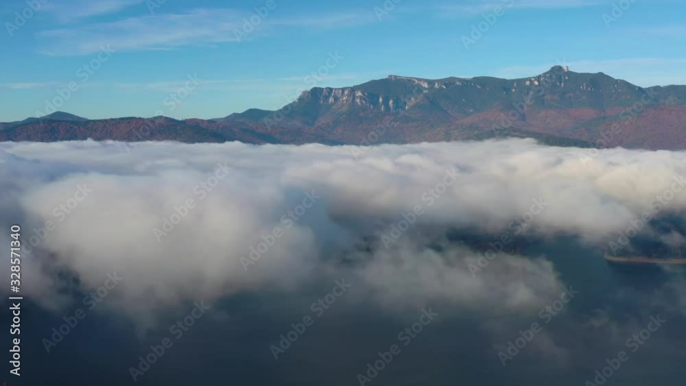 Mist cloud over mountain lake, flying drone in Romanian Carpathians Mist cloud over mountain lake, flying drone in Romanian Carpathians