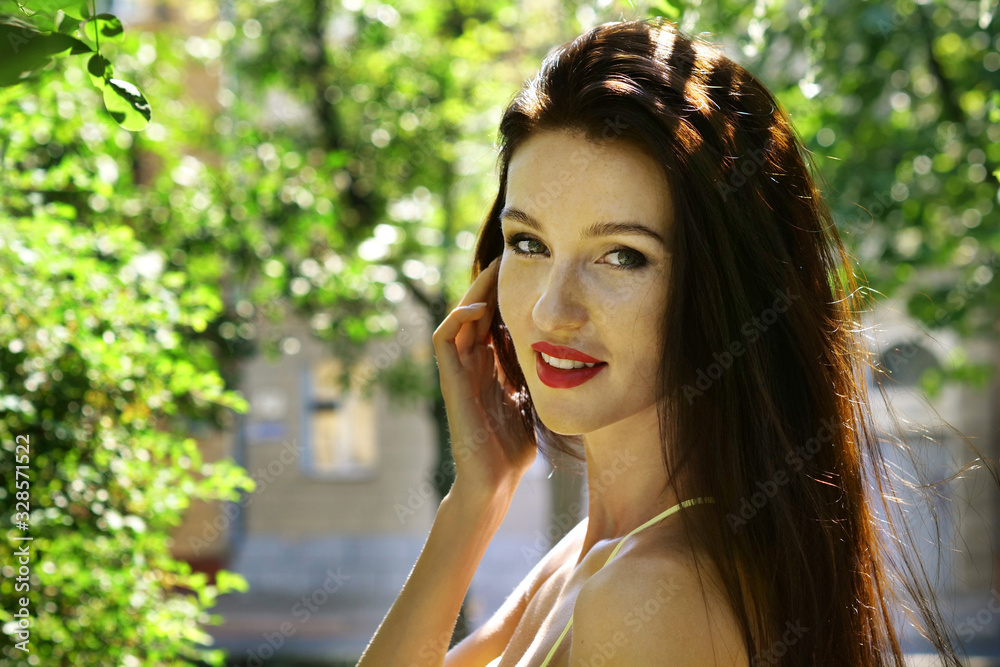Portrait of beautiful young brunette woman smiling and looking at camera
