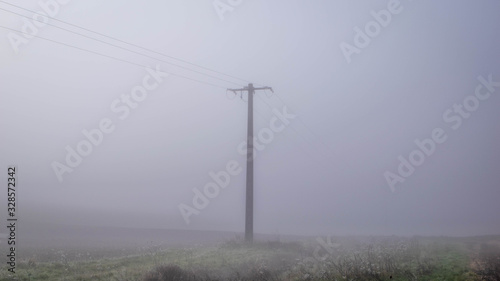 close up electric pole in winter mist © TMC