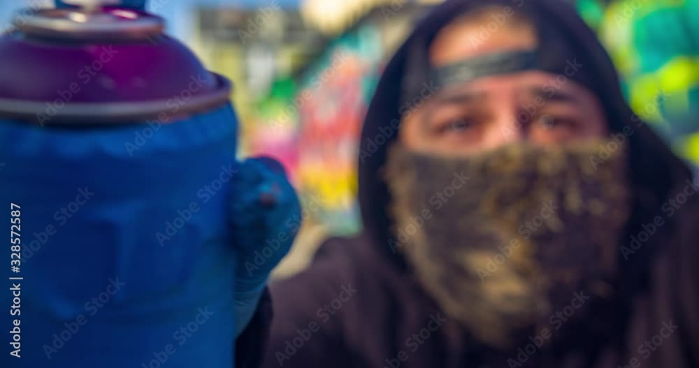 Graffiti artist spray painting in alley, filmed in 4K RAW