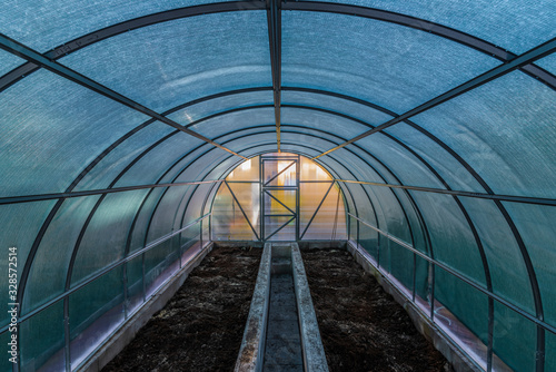 Interior of empty greenhouse before spring with concrete walls