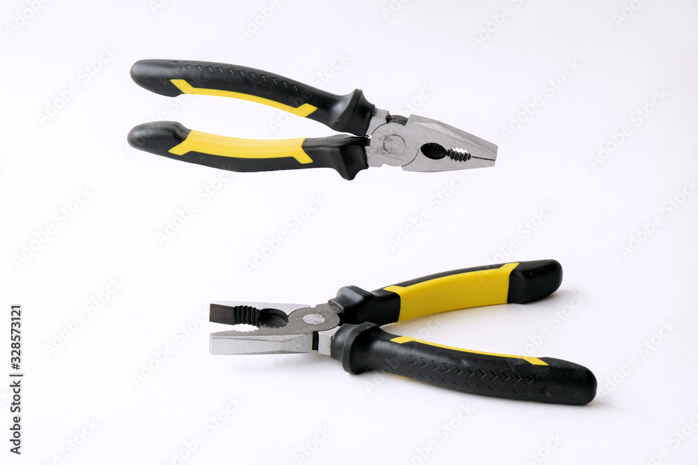 Pliers for black repair works with yellow inserts on white background Pliers for black repair works with yellow inserts on white background