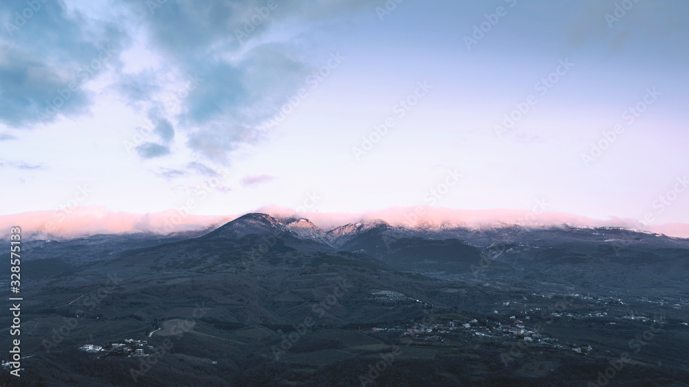 Mountains. Pink sunrise. Small towns in the valley.