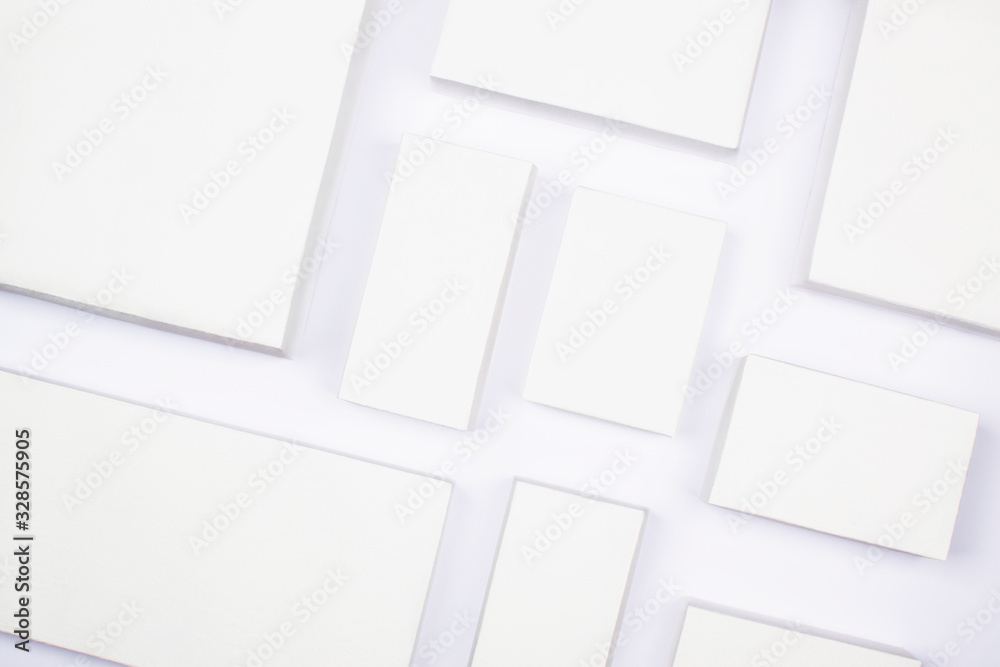 White cardboard boxes on a white background, concept of shopping and delivery. Many boxes of different sizes, packing goods. Recyclable packaging zero waste. Online shopping, buying with gadgets. - obrazy, fototapety, plakaty 
