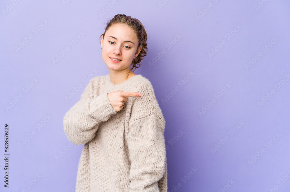 Young caucasian woman on purple background looks aside smiling, cheerful and pleasant. Young caucasian woman on purple background looks aside smiling, cheerful and pleasant.