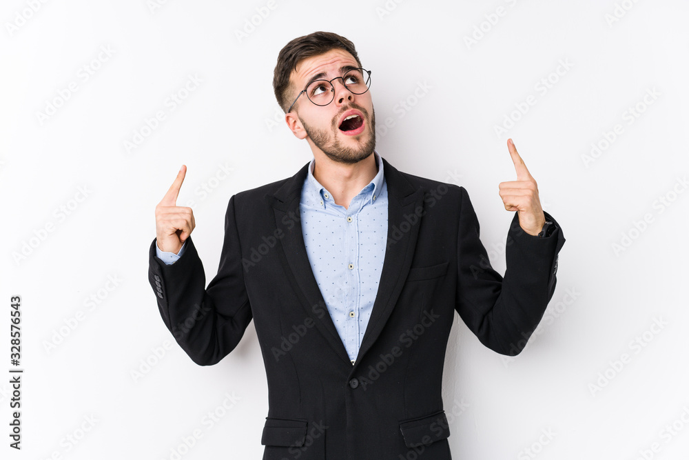 Young caucasian business man posing in a white background isolated Young caucasian business man pointing upside with opened mouth. Young caucasian business man posing in a white background isolated Young caucasian business man pointing upside with opened mouth.